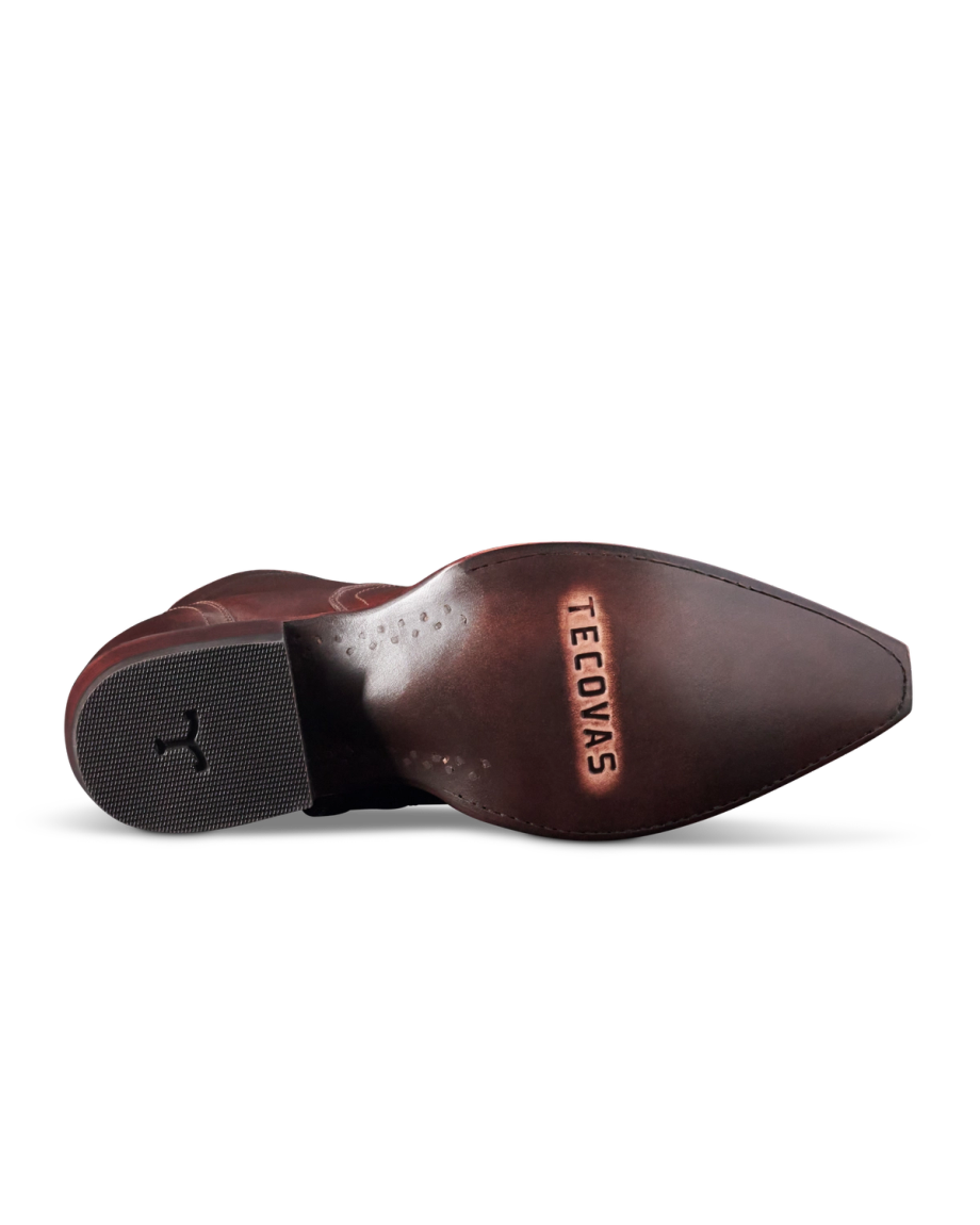 Brown leather cowboy boot sole with the brand name "Tecovas" embossed on it. The heel has a rubber grip insert and a subtle horse logo.