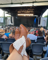 Women's boots propped up on back of a chair at a concert 