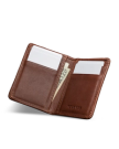 Open brown leather wallet with card slots and visible cash, embossed with the word "Tecovas" on the right side.