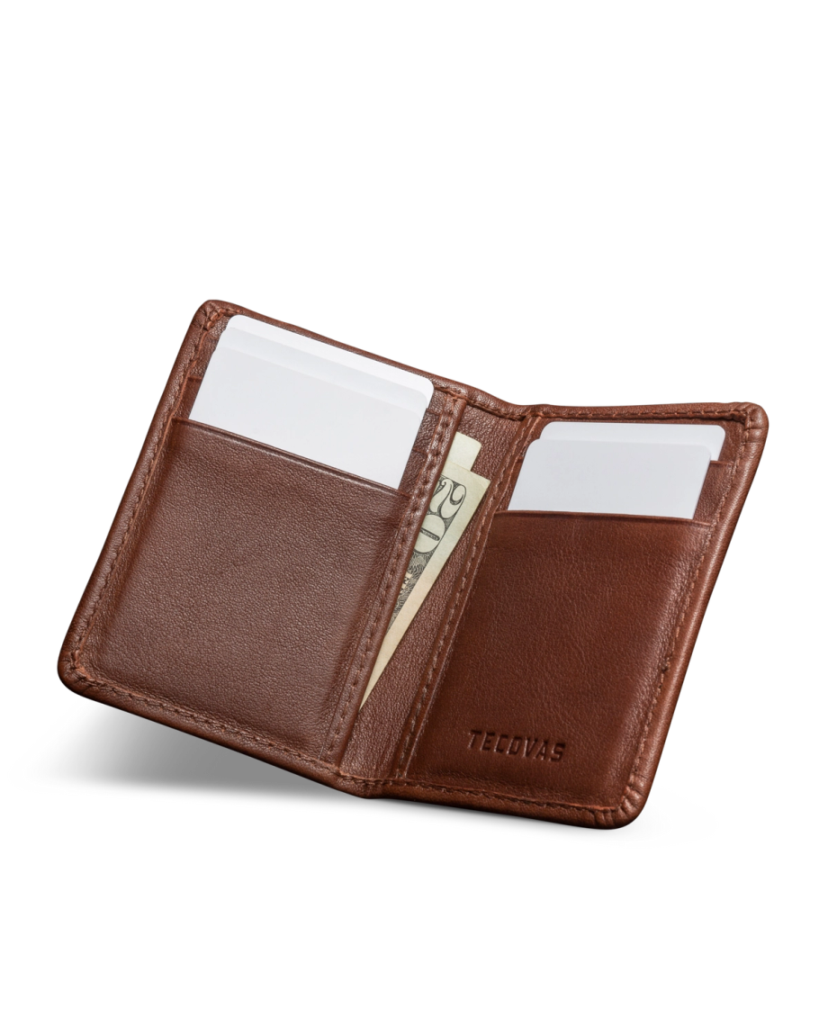 Open brown leather wallet with card slots and visible cash, embossed with the word "Tecovas" on the right side.