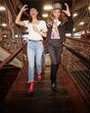 Two woman dressed up at the Rodeo wearing cute outfits and laughing