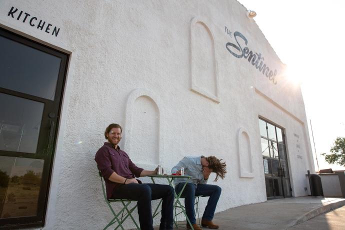 two men sitting outside laughing