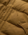 Close-up image of a puffy brown jacket with visible stitching, a front pocket, and metal snap buttons.