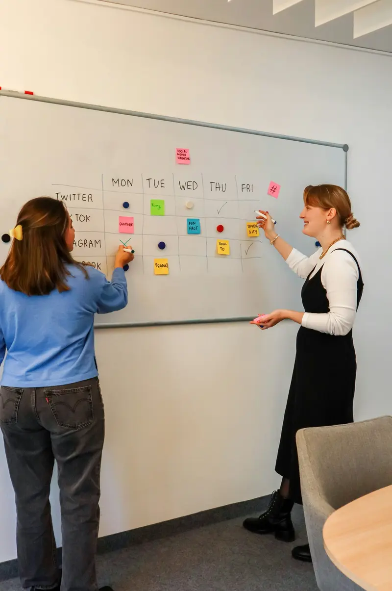 Marketing team planning strategy in front of a whiteboard