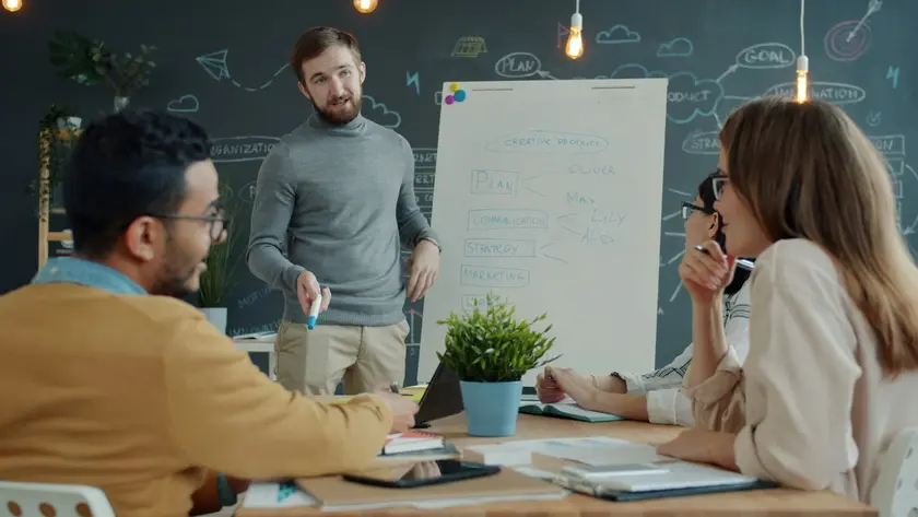 Presenter explaining marketing strategy at whiteboard