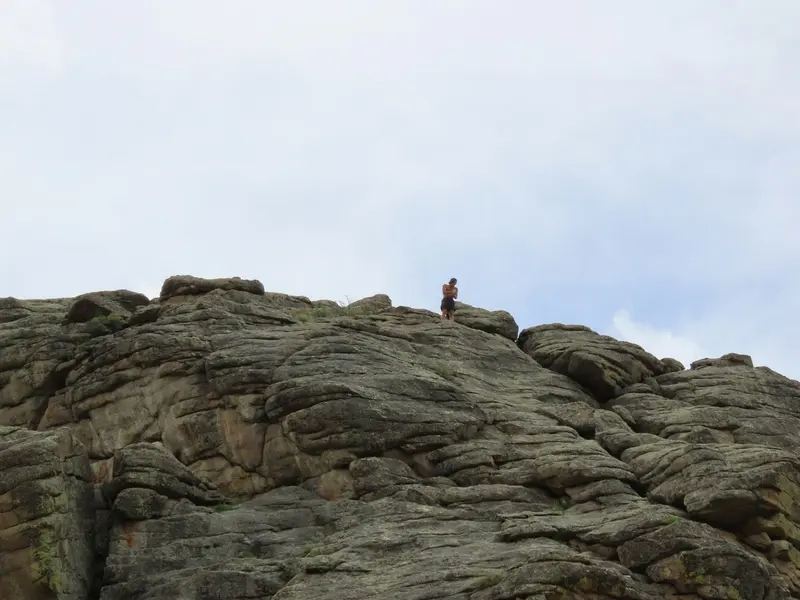 Person standing on a mountain cliff embracing new challenges