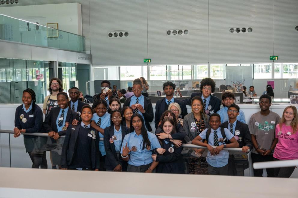 Around 17 students standing in group showing the badges they created