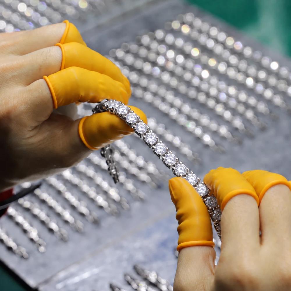 Jewelry worker inspecting stone setting on a custom bracelet