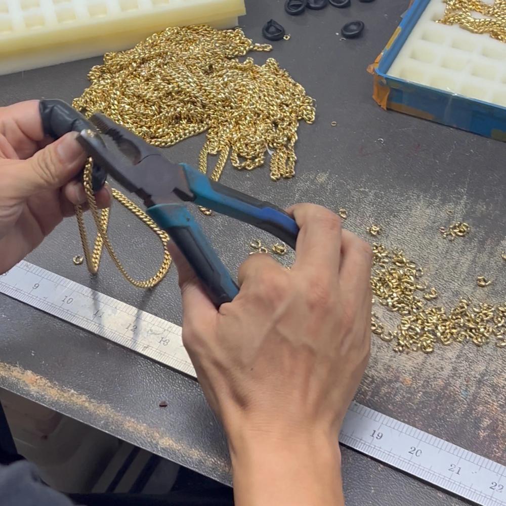 Worker assembling gold chains during custom chain production