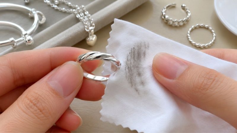 Real silver may leave slight dark marks on a white polishing cloth because silver can oxidize over time.