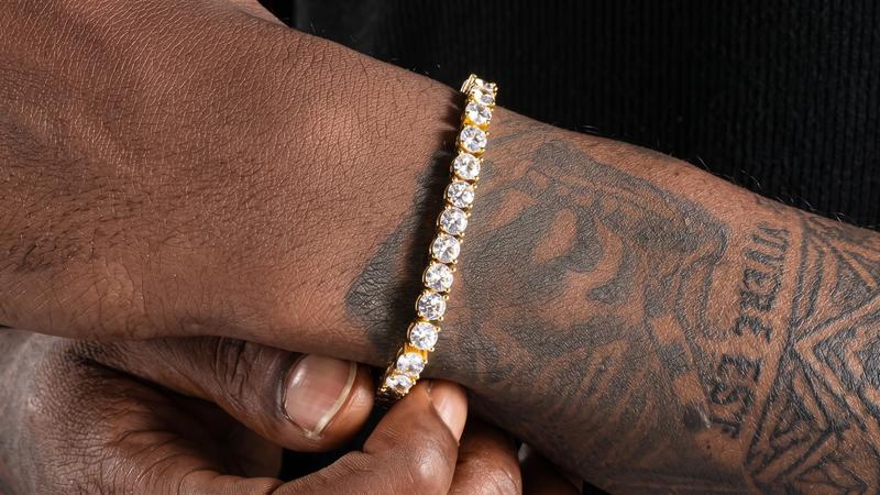 Gold tennis bracelet with continuous stone setting worn on wrist