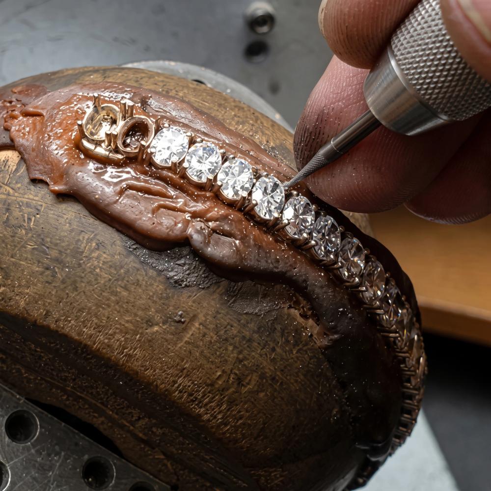 Jewelry worker setting stones on a custom bracelet during production