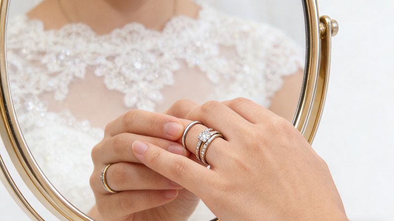 After marriage, couples wear the engagement ring together with the wedding rings as a unified symbol of commitment.