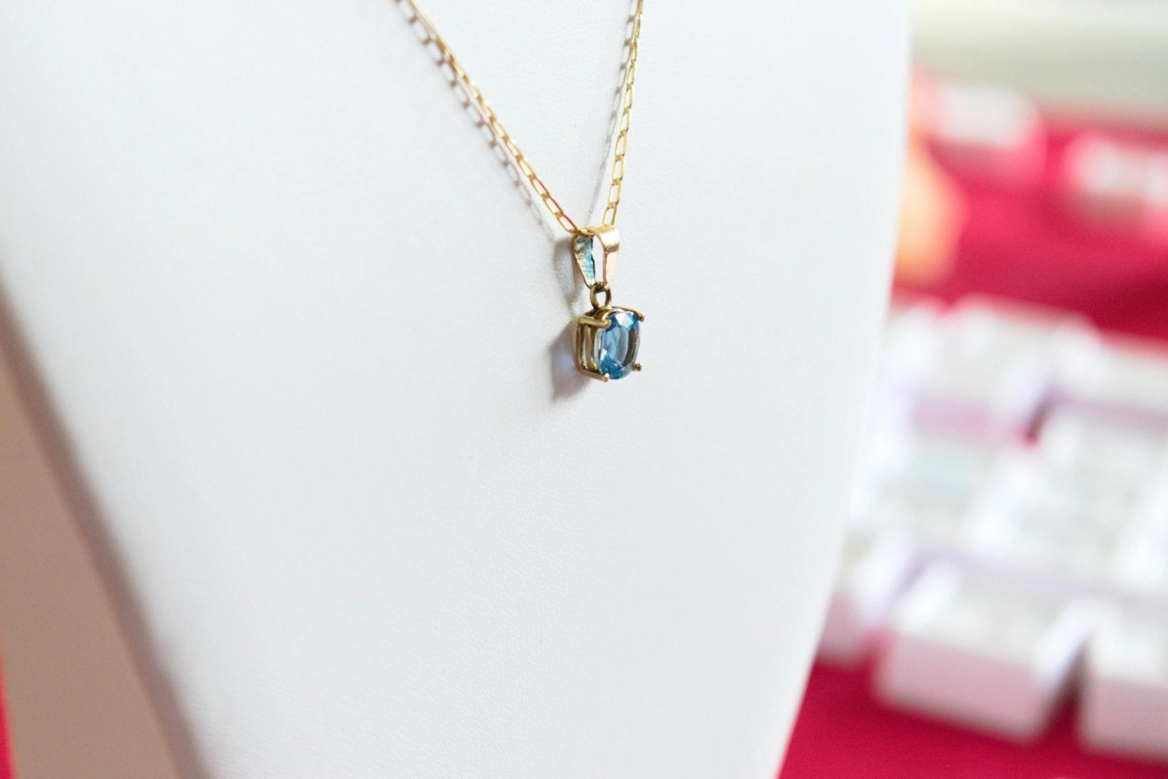A pendant necklace on a necklace holder stand