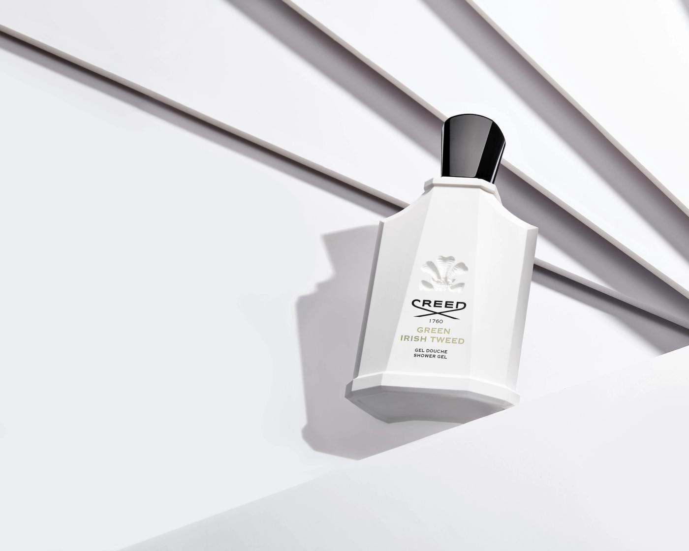 Creed Green Irish Tweed shower gel bottle against white ribbed surface with directional shadow, fragrance photography London