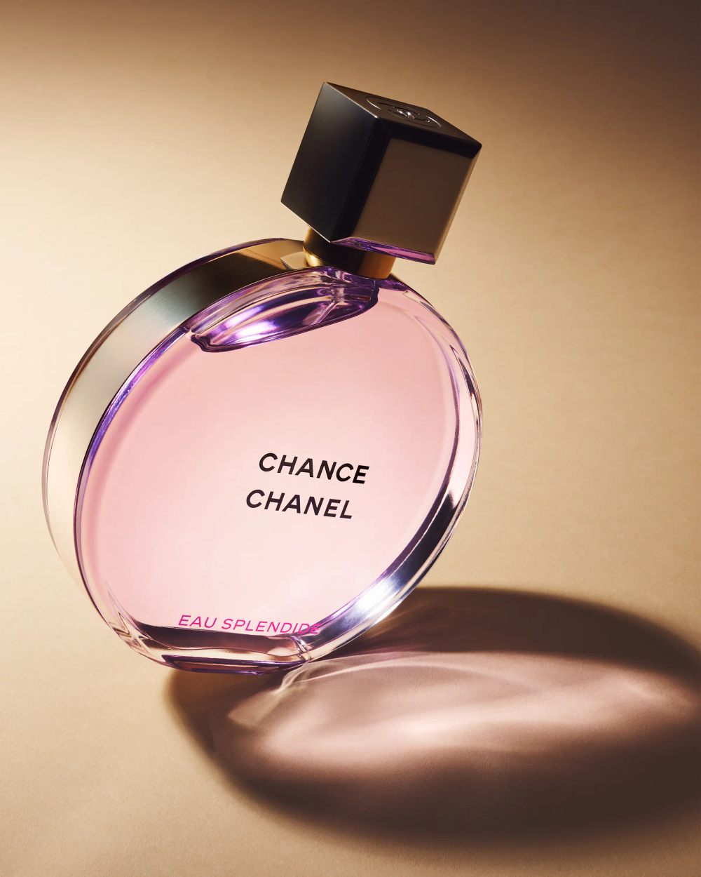 Chanel Chance Eau Splendide bottle tilted on warm beige surface casting long directional shadow, luxury fragrance still life photography London