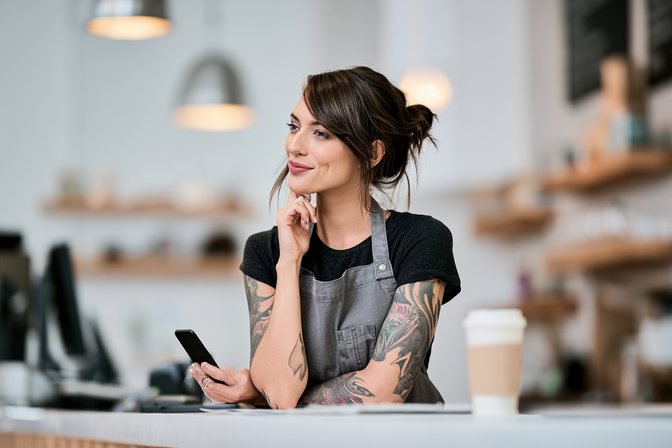 A local service business owner at their shop counter responding quickly and confidently to a new customer inquiry.