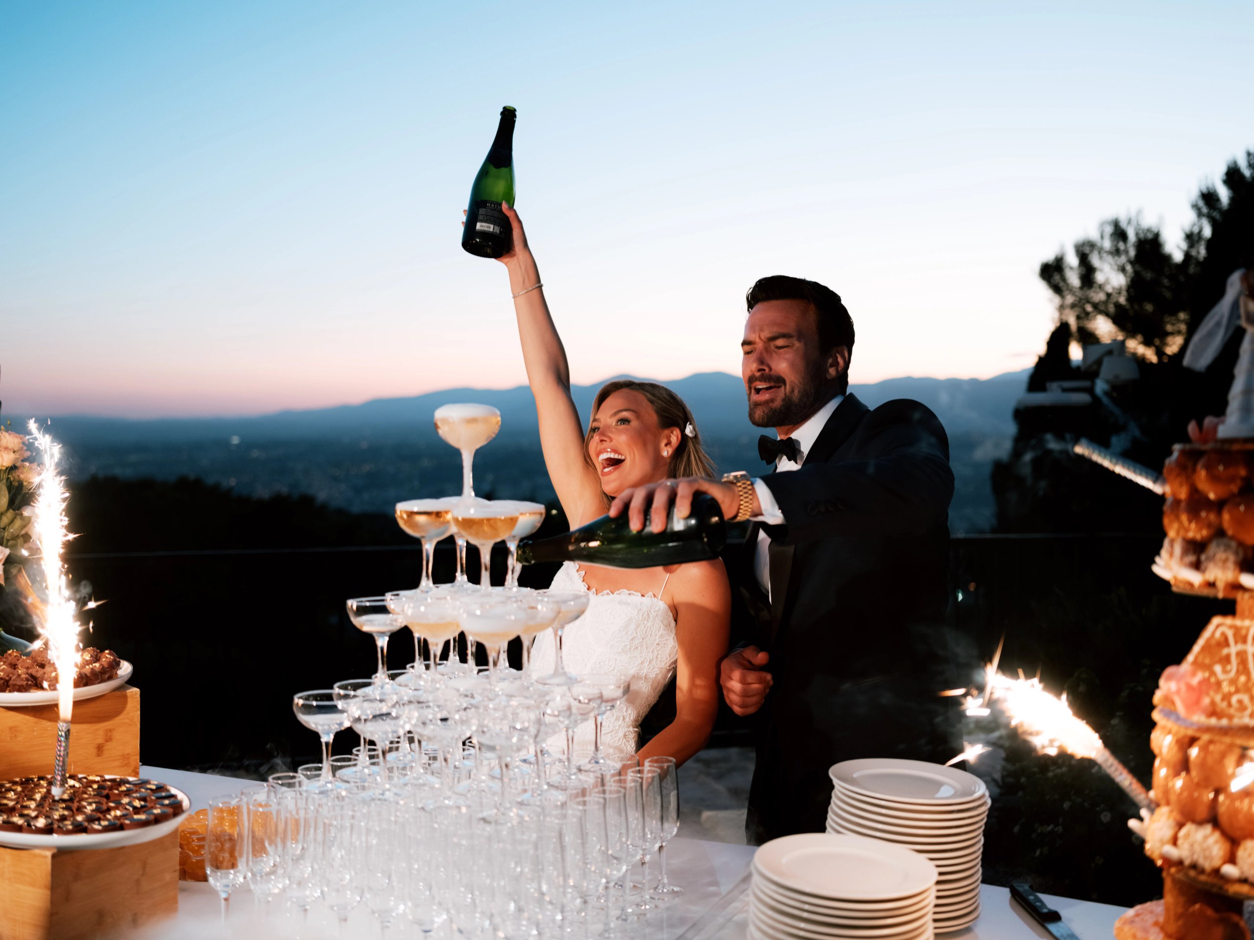 A couple beside a champagne tower at sunset