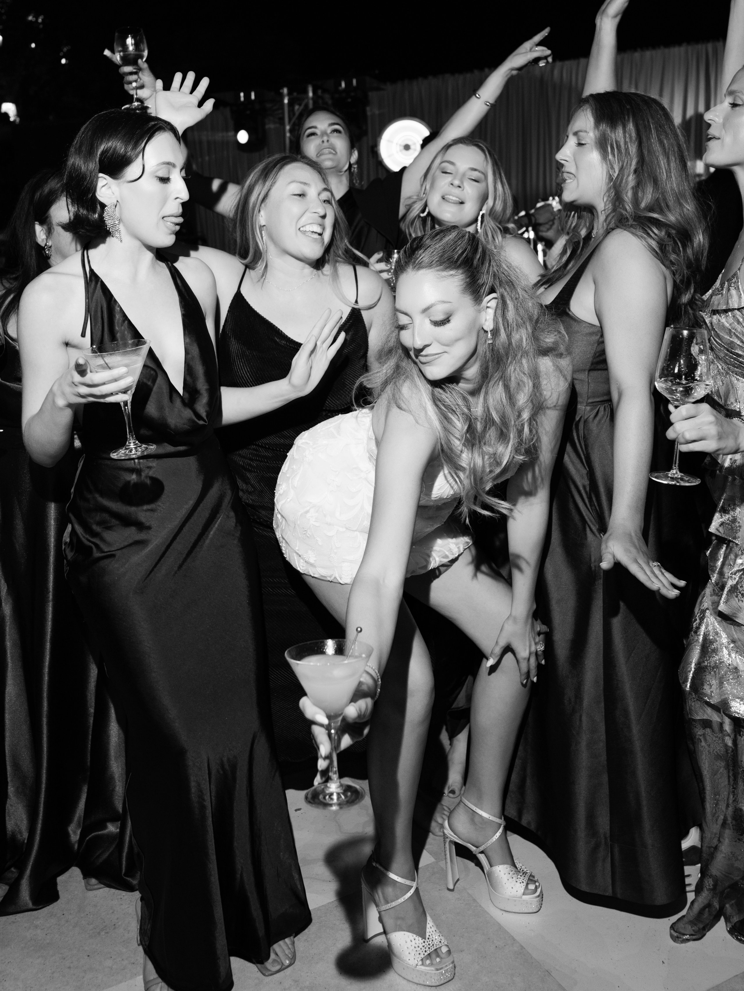 Guests dancing and laughing at a celebration, in black and white