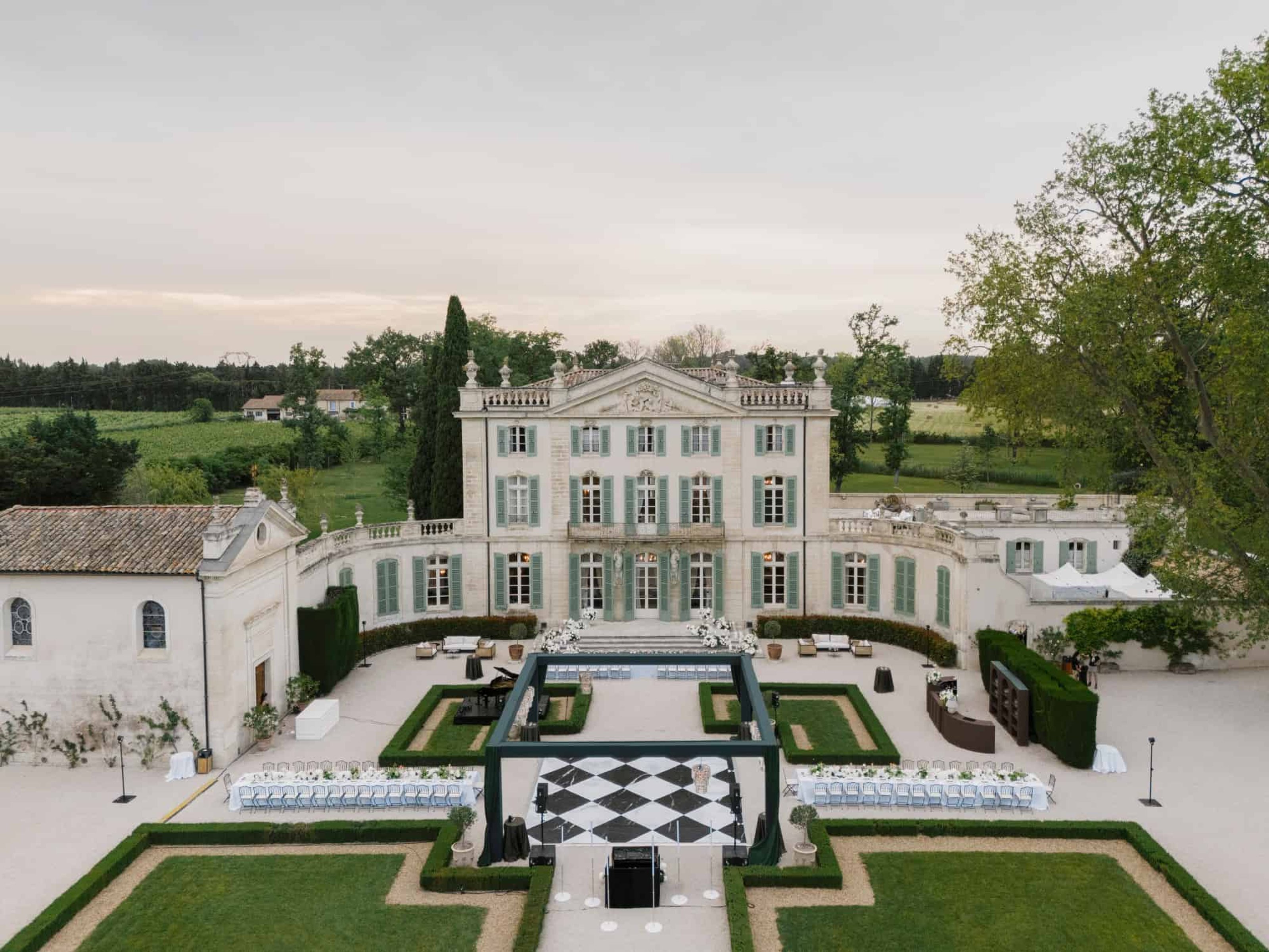 Château de Tourreau from above, its French garden set with dinner tables and a chequerboard dance floor