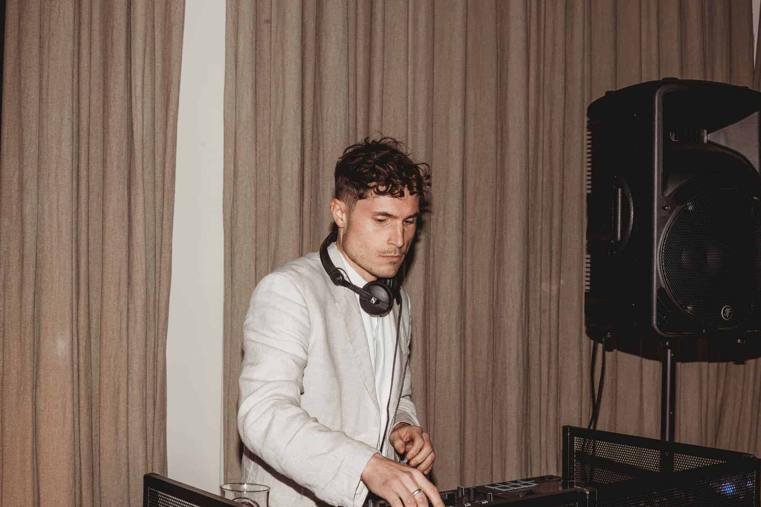 A DJ in a white jacket at the decks