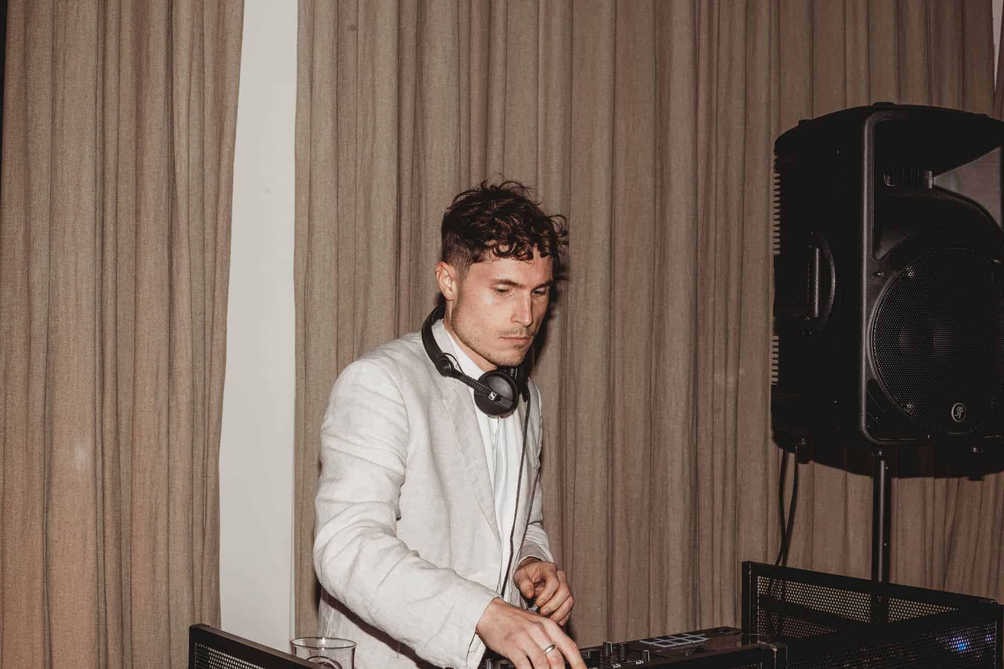 A DJ in a white jacket at the decks