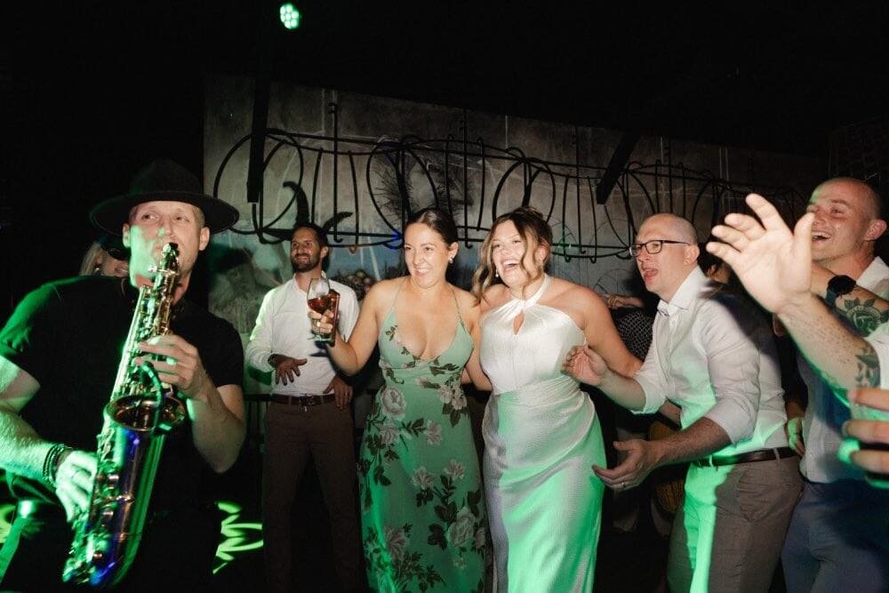 A saxophonist playing as guests dance