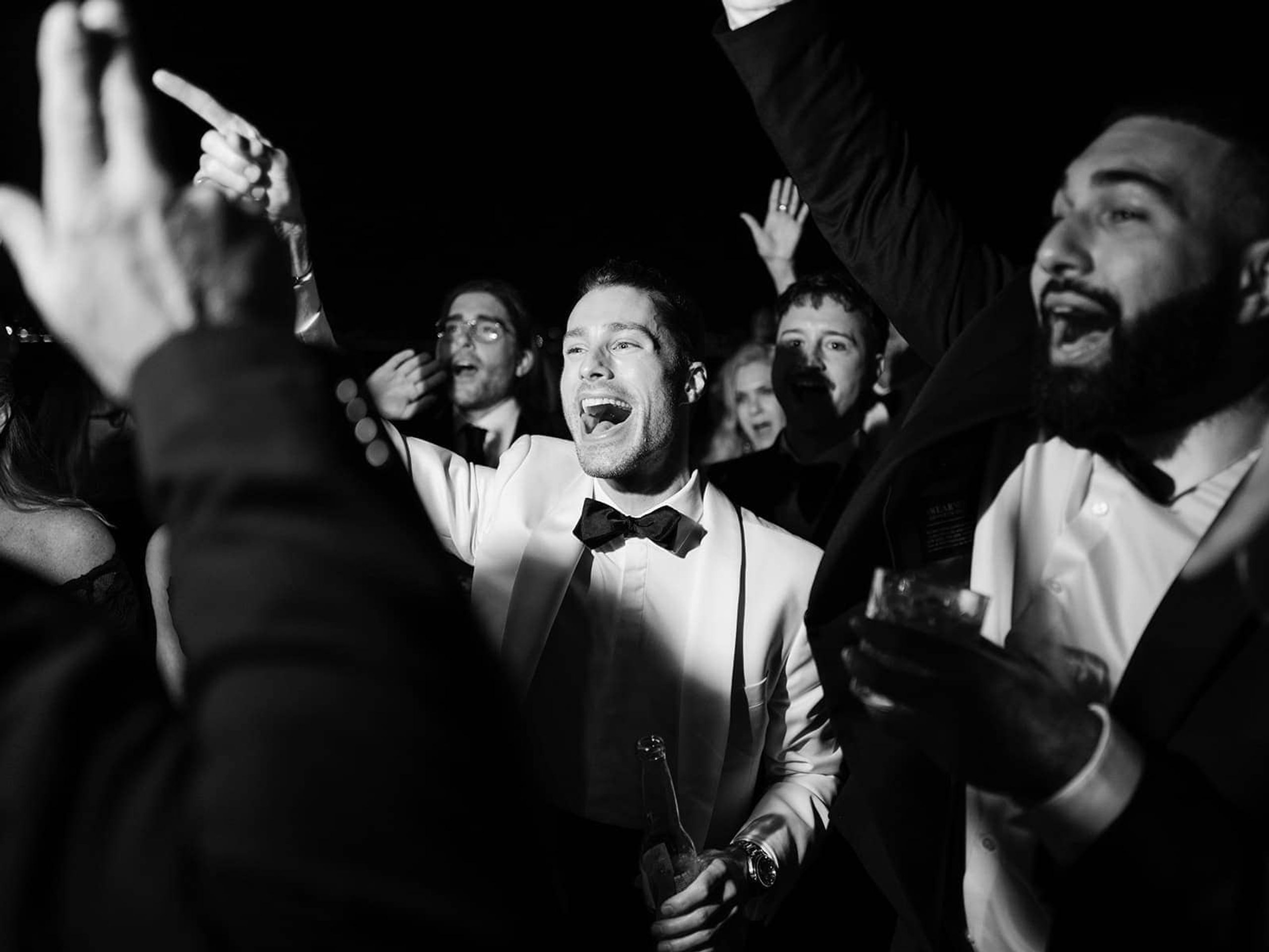 Guests dancing together at an evening celebration, in black and white