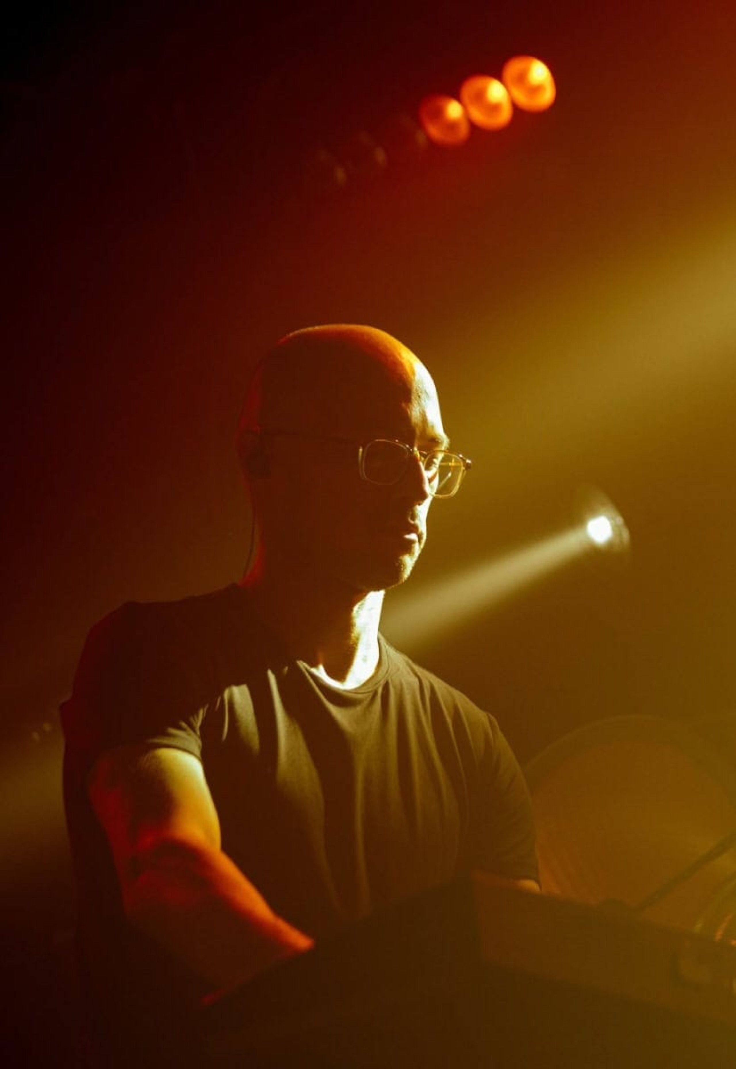 A performer at the keys in warm stage light