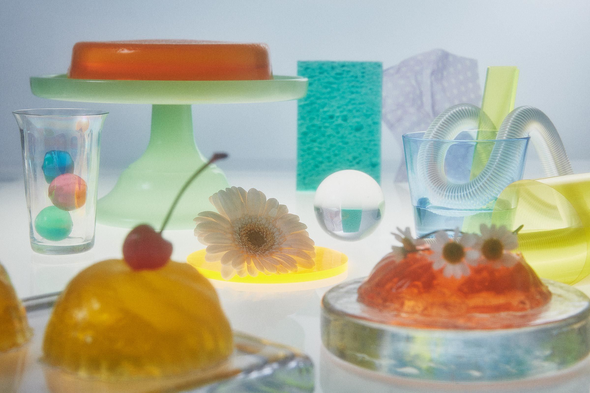 A table packed with flowers, jello, marbles, candy, and plastic samples