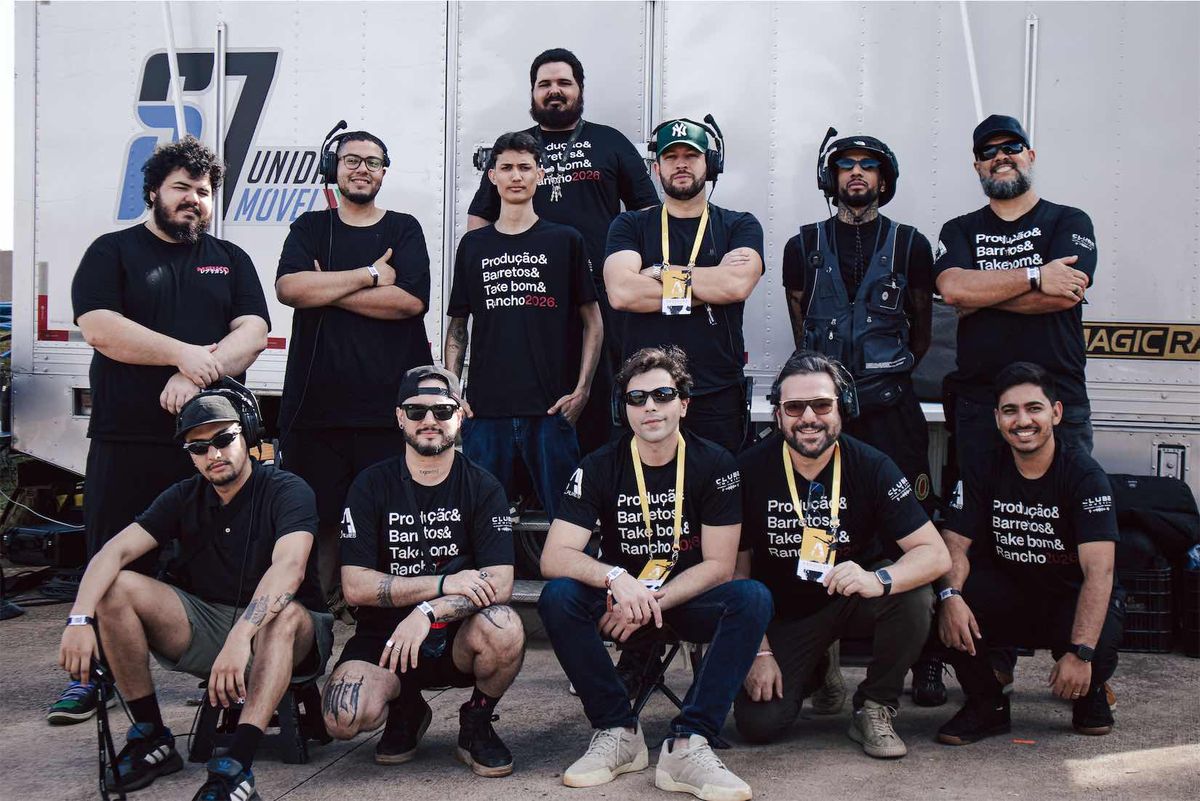 A equipe da YAD em Barretos, doze pessoas de camiseta preta e headsets posando na frente da unidade móvel