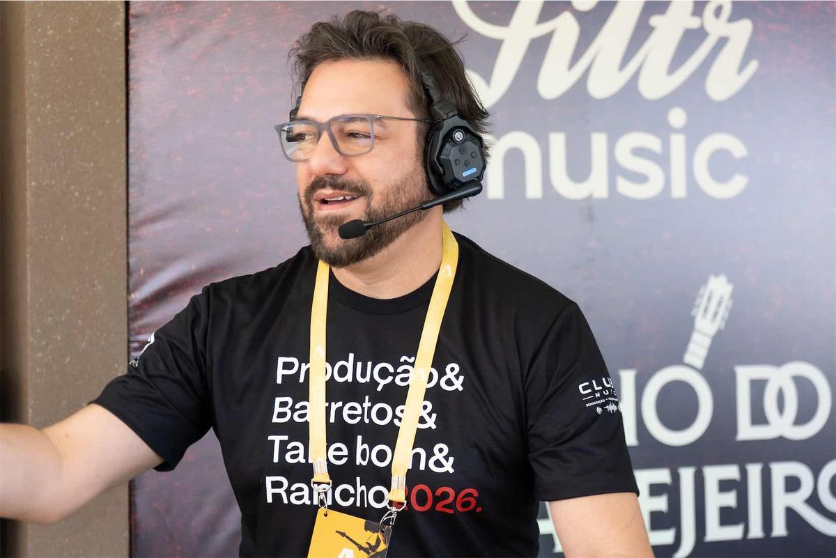 Integrante da equipe de headset e óculos com a camiseta escrita Produção & Barretos & Take bom & Rancho 2026