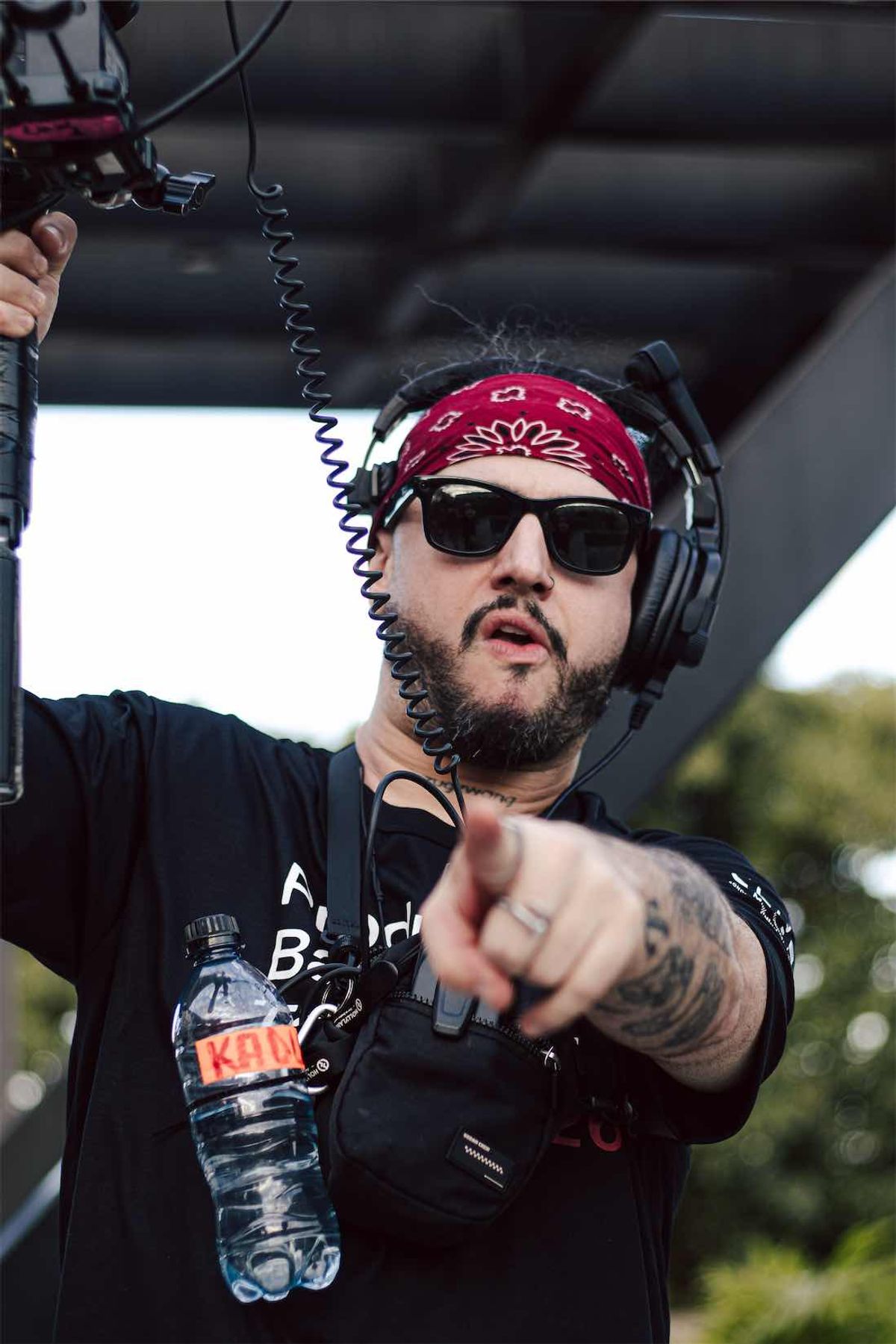 Operador de bandana e headset apontando para a câmera