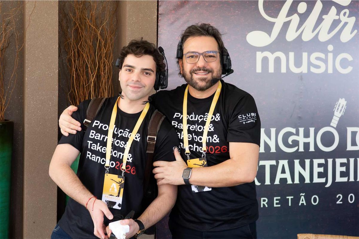 Alex, da A1 Filmes, de headset ao lado de um integrante da equipe, diante do painel Filtr Music e Rancho do Sertanejeiro