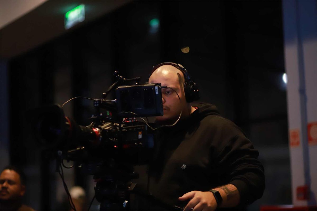 Operador com headset enquadrando pelo monitor de uma câmera de cinema