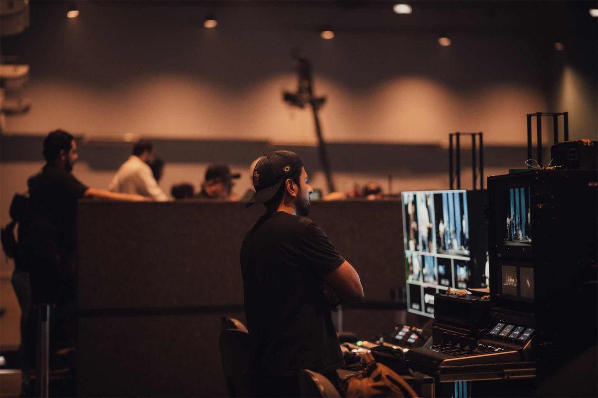 Operador de costas diante dos monitores de multiview e do rack de gravação