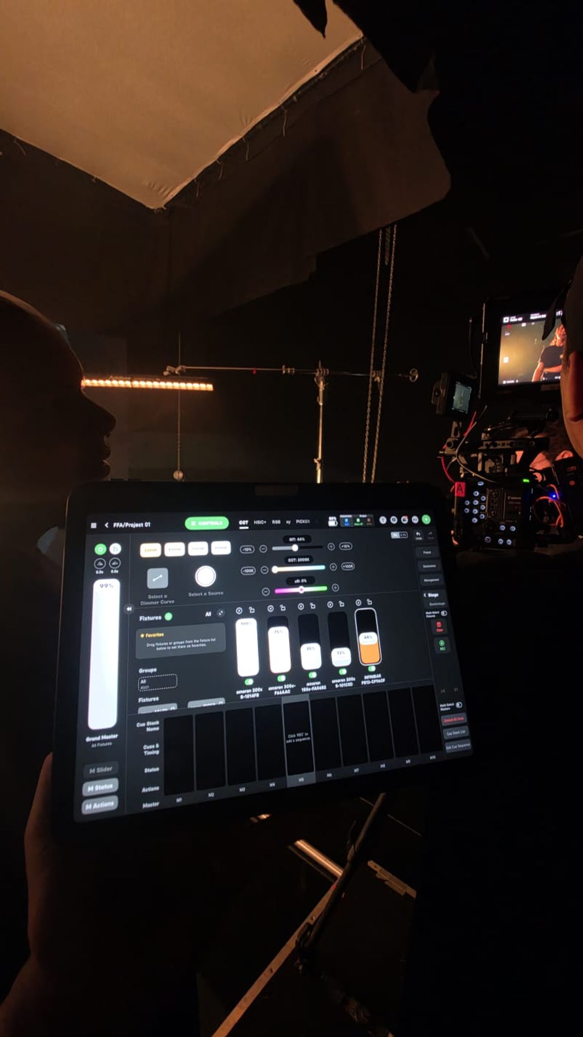 Tablet com o aplicativo de controle de iluminação aberto no projeto do clipe, câmera e monitor ao fundo