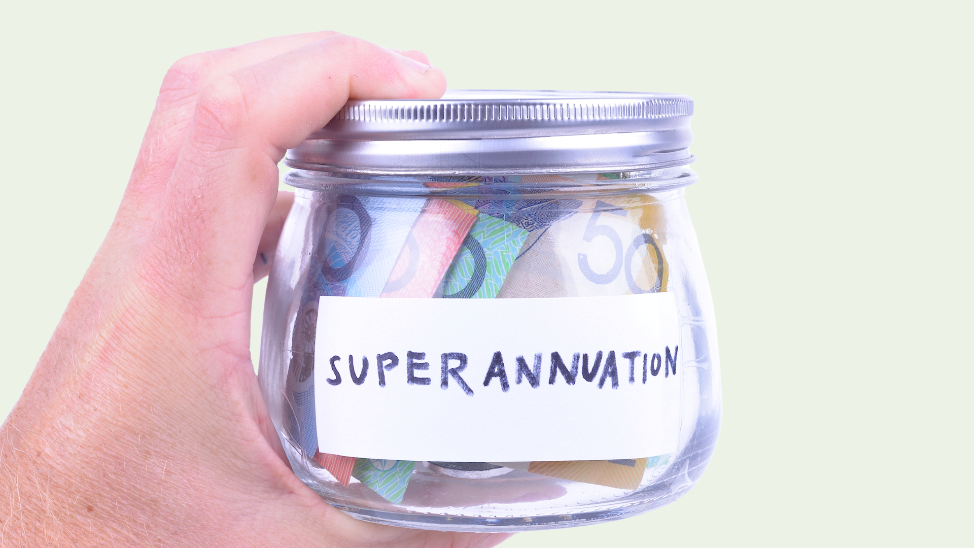 Hand holding a jar with the label Superannuation containing Australian dollars 