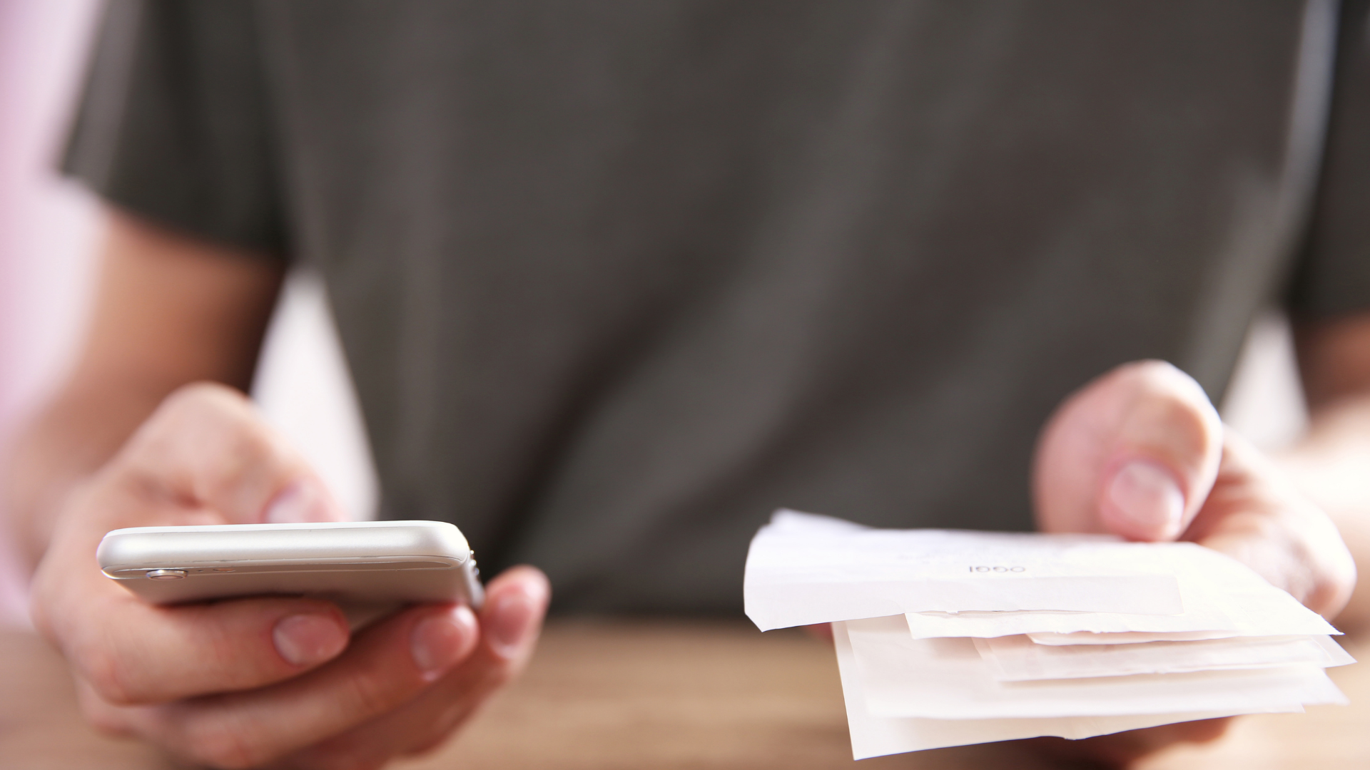 Person holding a phone and recording their business receipts for taxation purposes