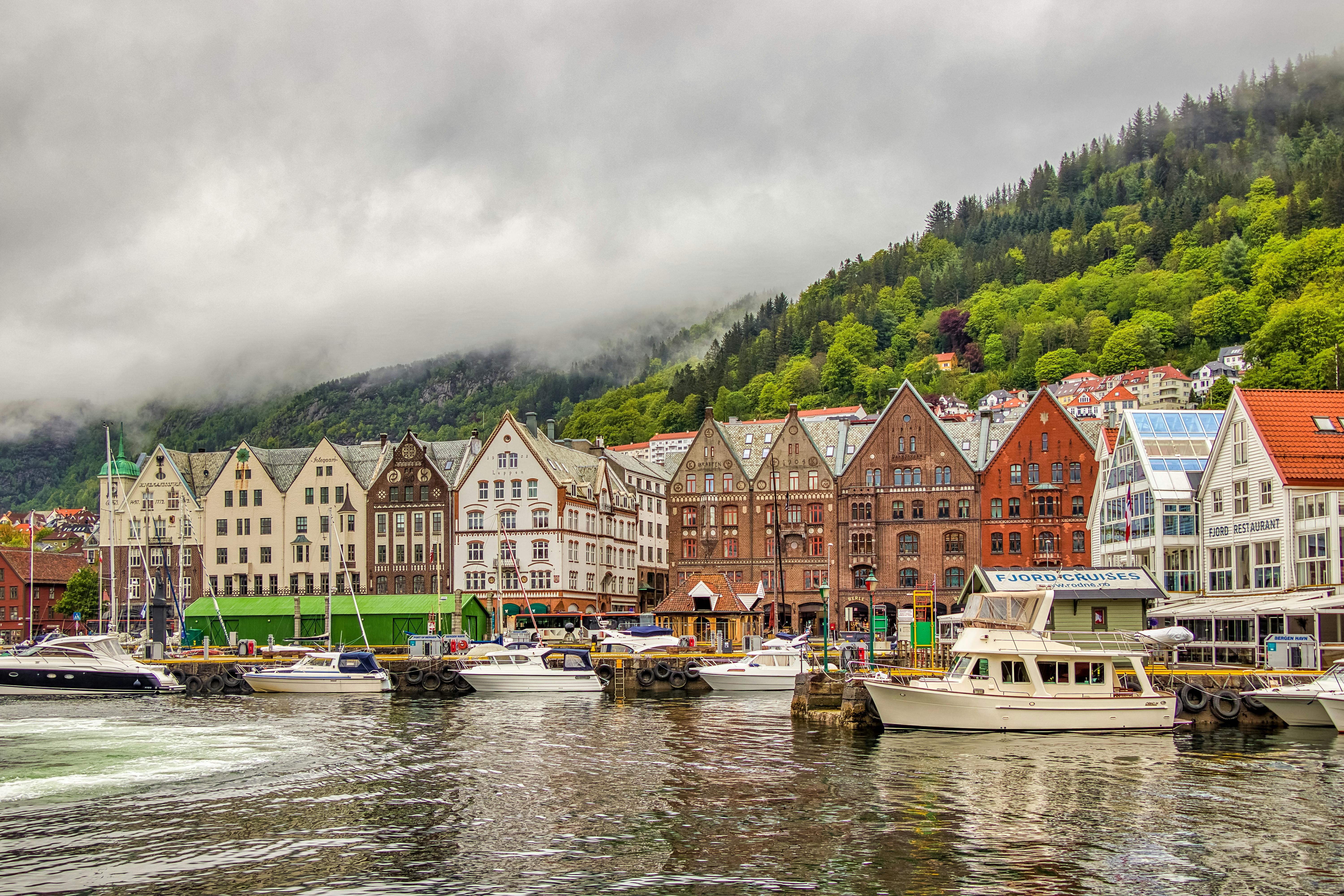 Bilde av en mindre norsk by med masse båter på bryggen.