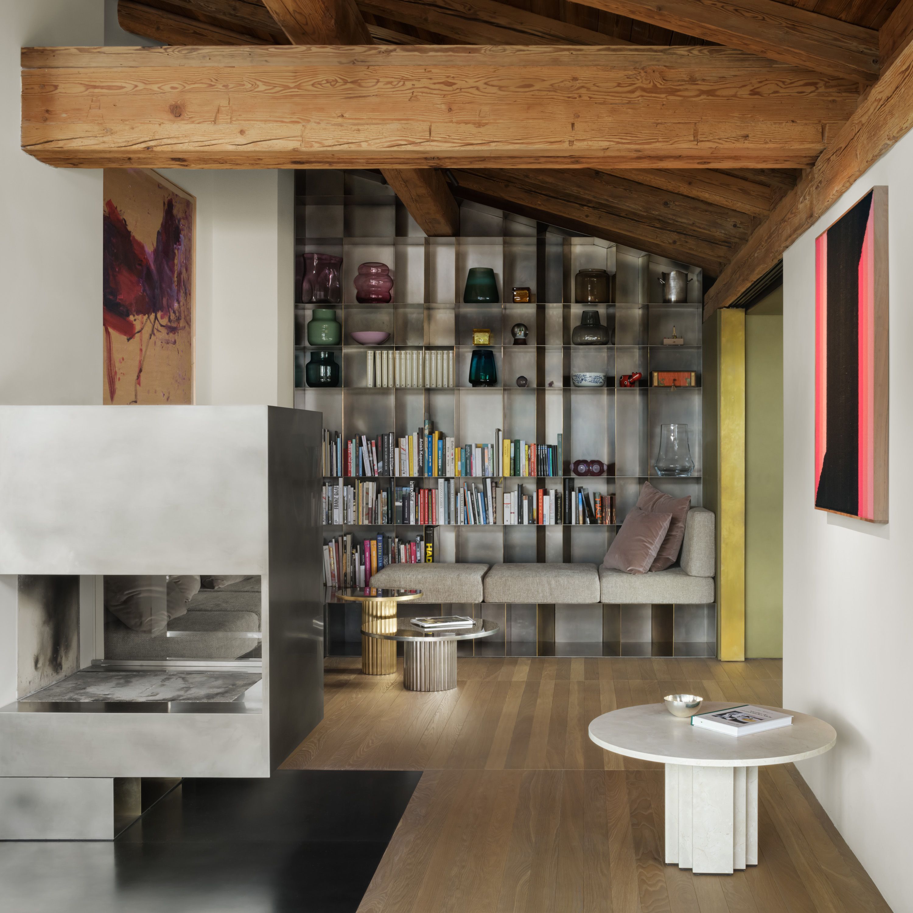 a living room with a fireplace , bookshelves , a couch and a table .