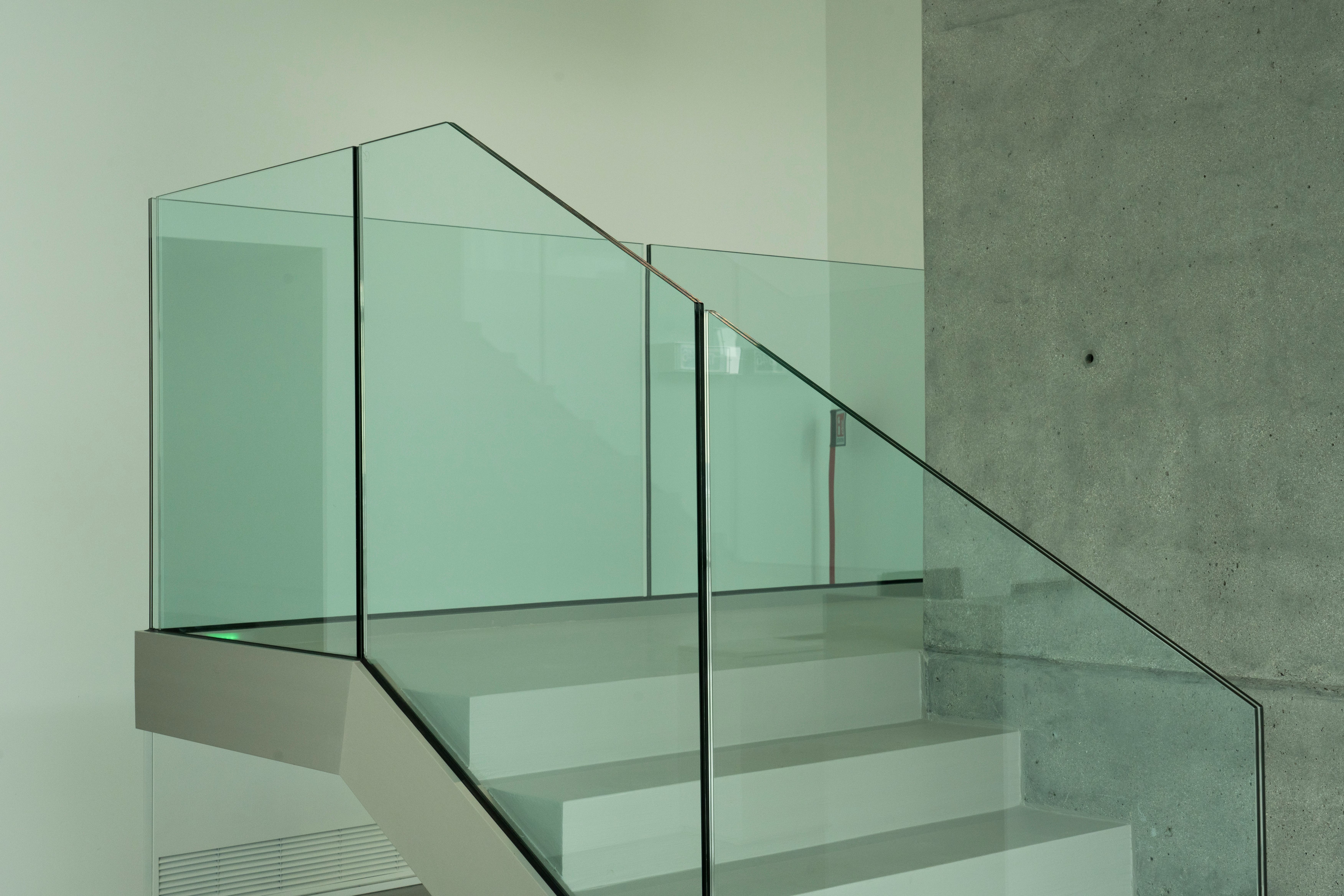 a modern staircase with a glass railing and concrete steps .
