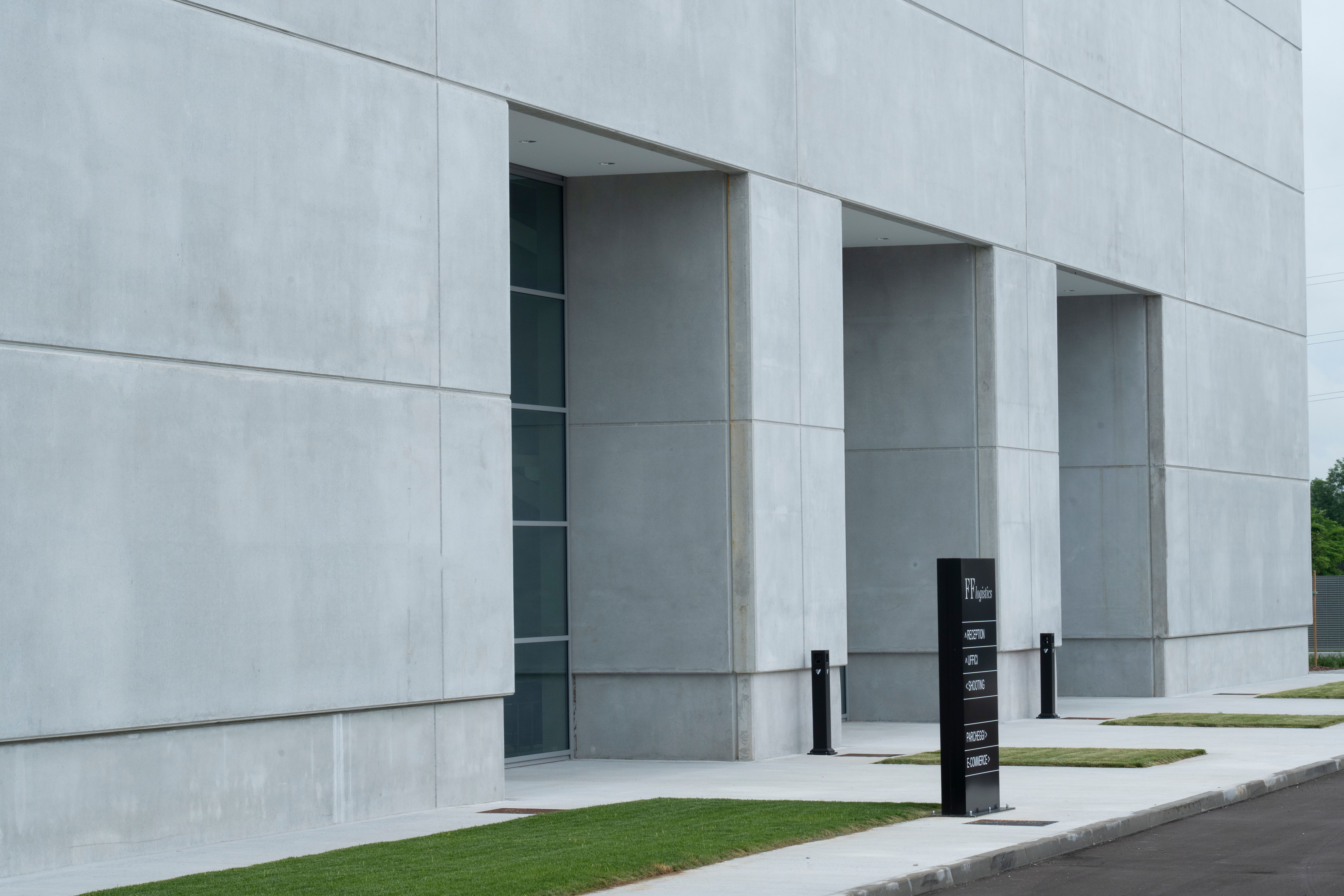 a large concrete building with a sign in front of it .