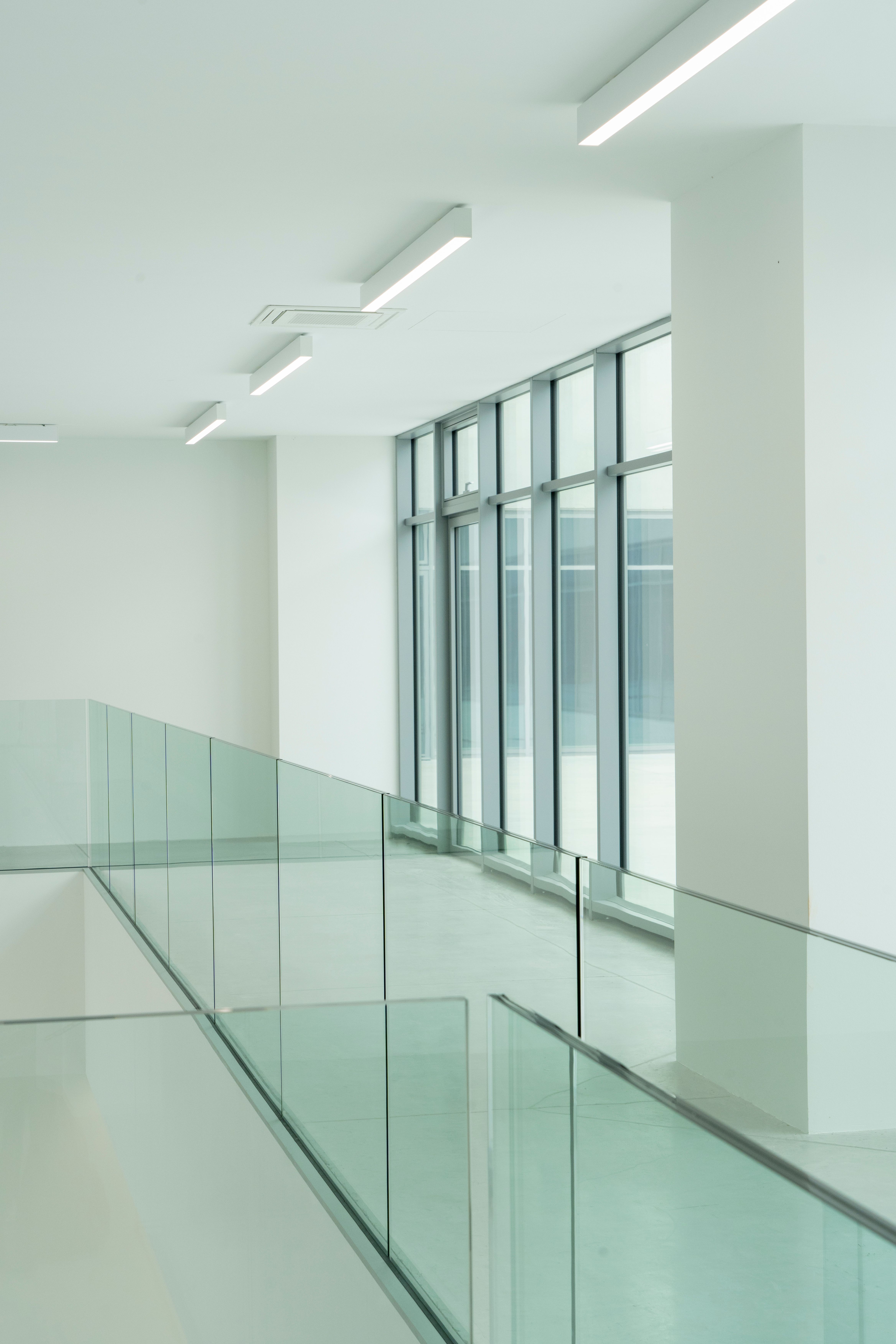 a hallway with a glass railing and lots of windows
