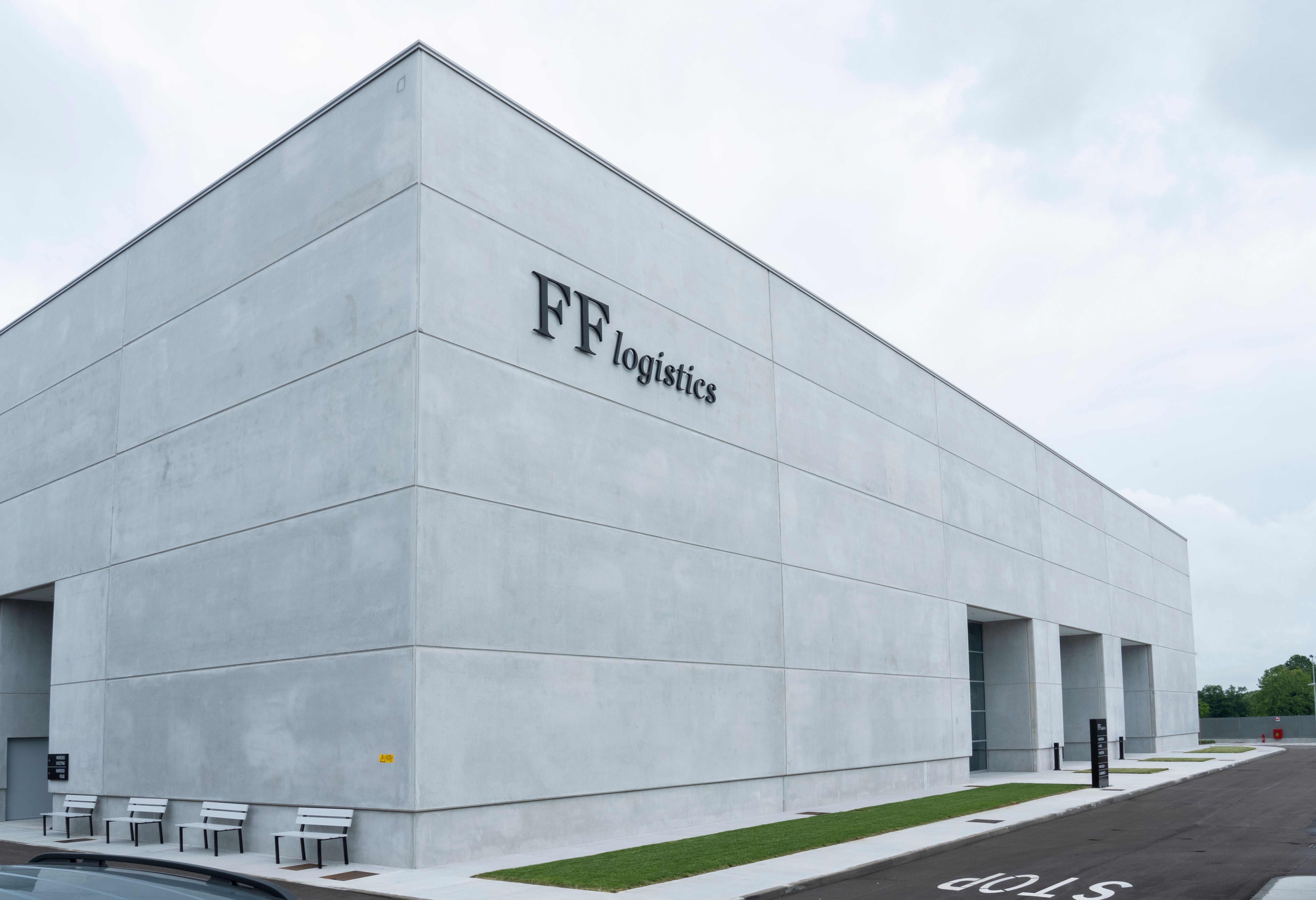 a large concrete building with a parking lot in front of it .