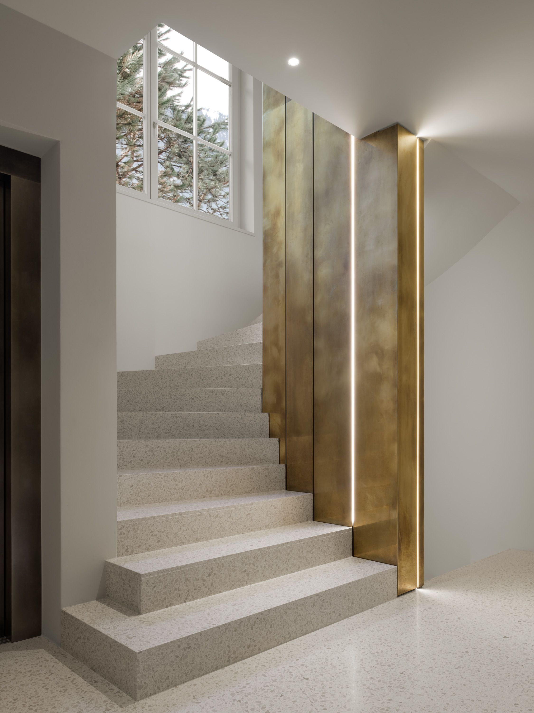 a hallway with brass sliding doors leading to a bathroom .