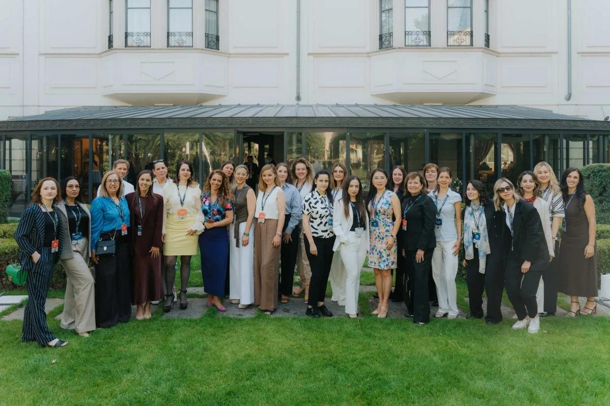 Around thirty women delegates standing together on the lawn outside the conference hotel