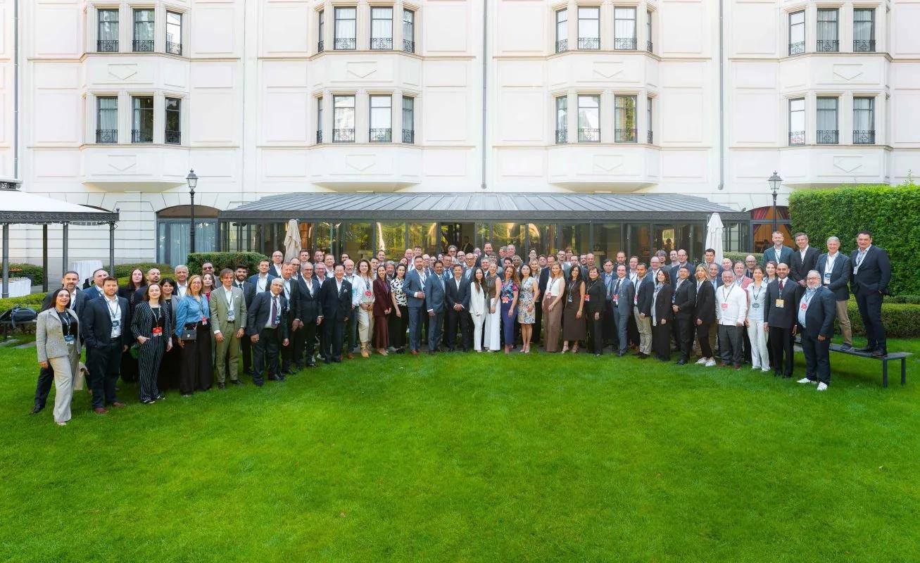 The full conference group, around a hundred delegates, photographed on the lawn outside the hotel