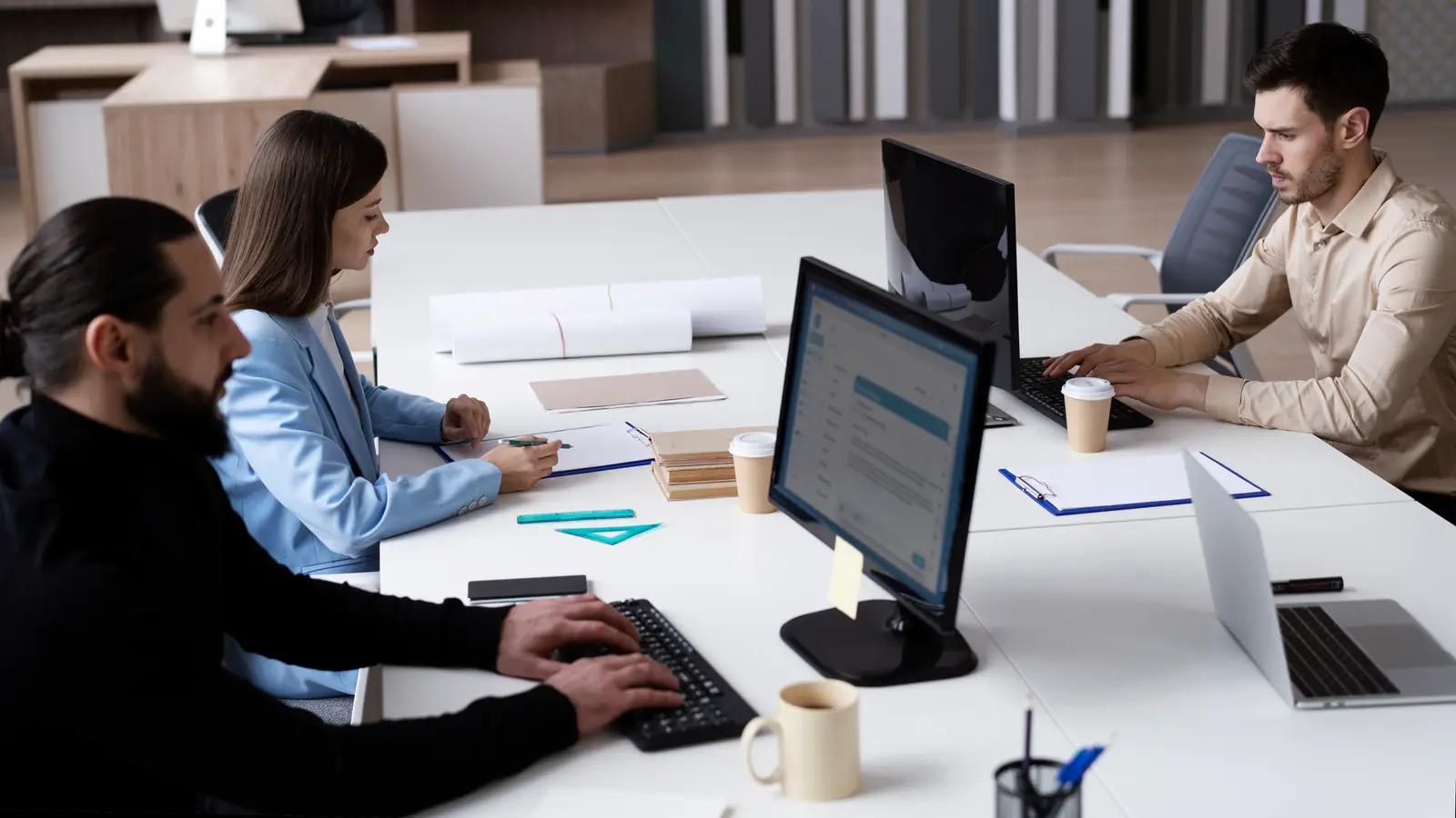 Colleagues working together at their desks in a bright office