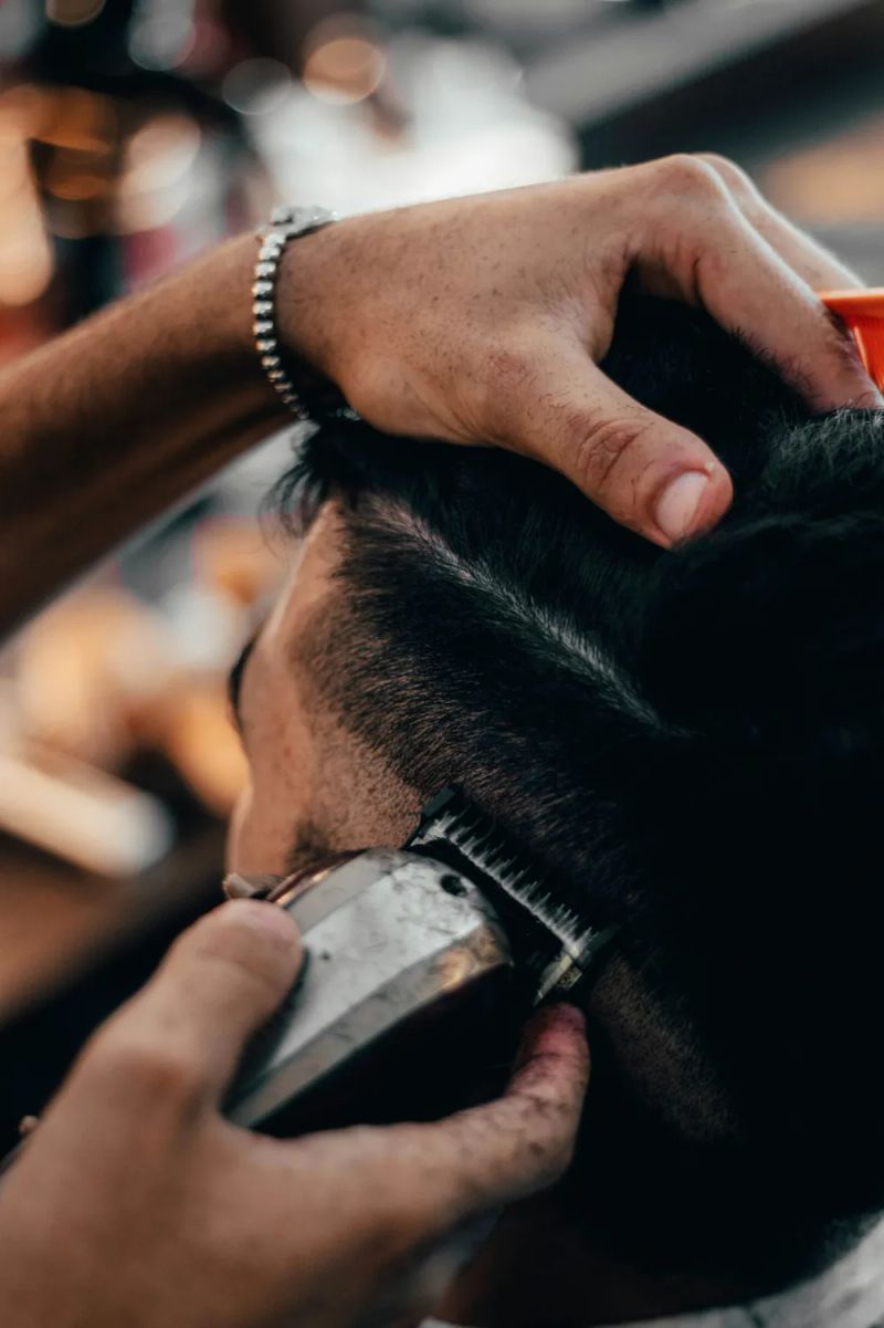 Barber strzyże włosy klienta maszynką